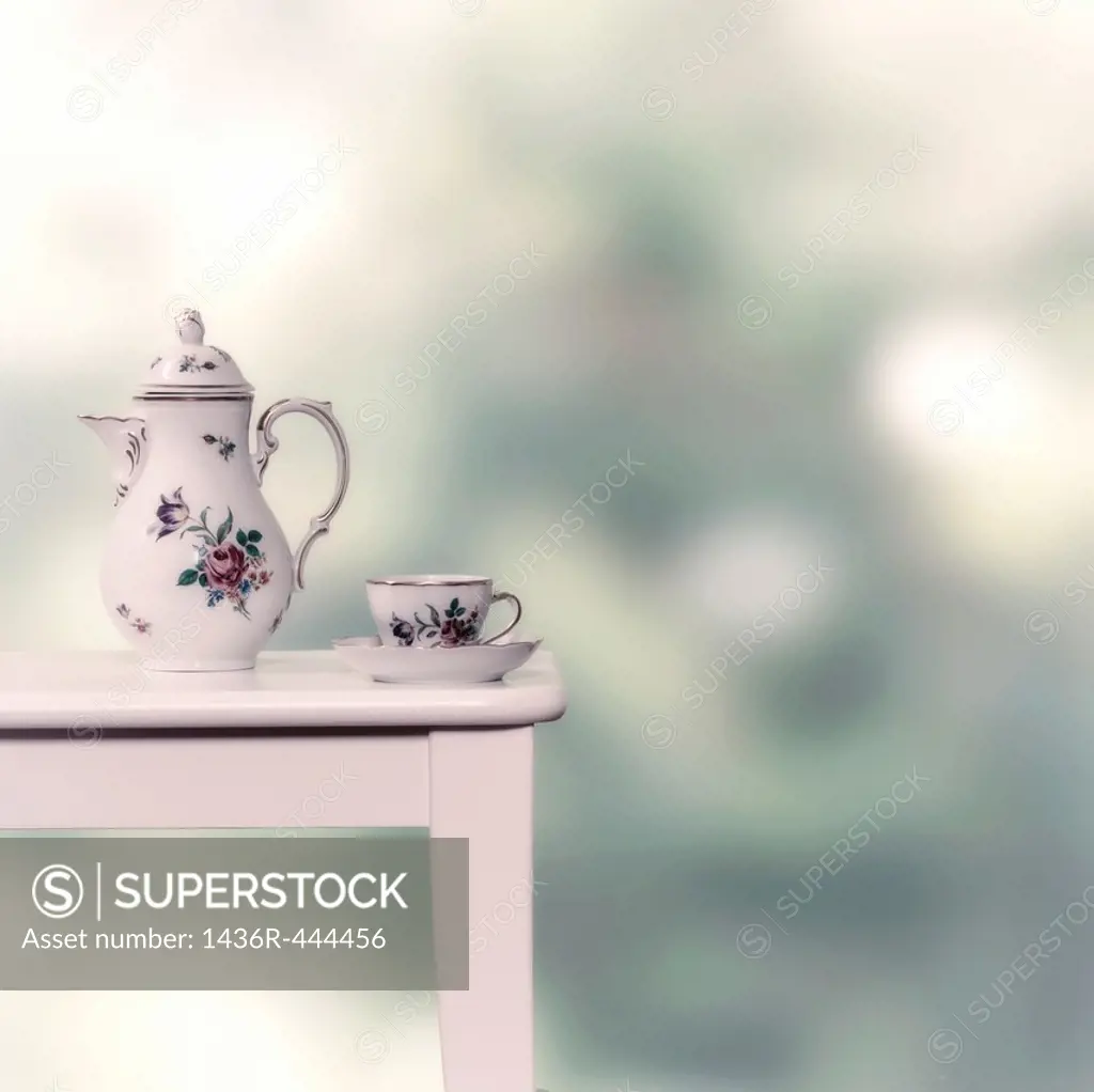 vintage tea pot and cup on a white stool