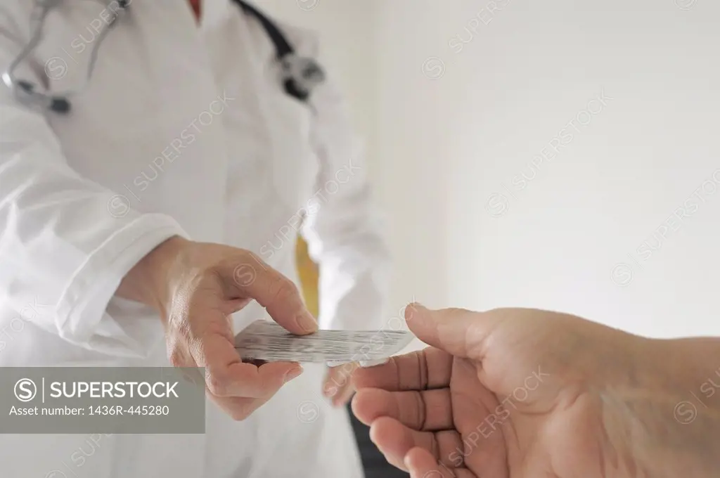 Doctor gives prescription drugs to patient