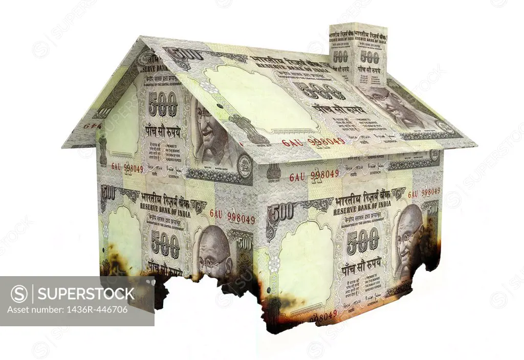 Conceptual shot of burned currency home representing home insurance