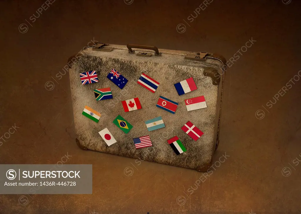 Conceptual image of national flags of different countries on suitcase representing global business travel