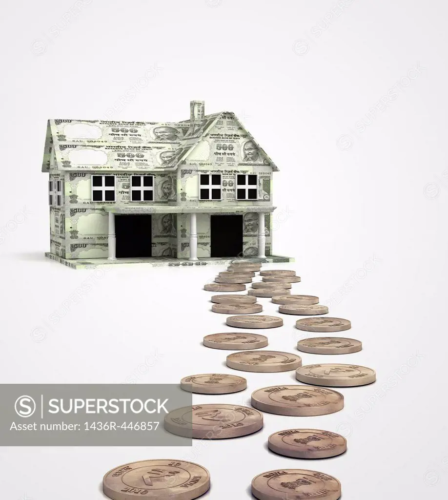Coins leading the path towards paper currency house isolated over white background representing home loan