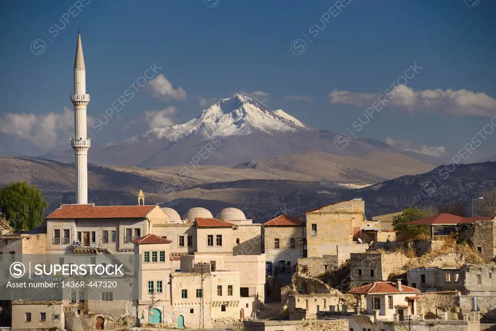 Houses and Mosque in Ortasihar with view of Mount Erciyes dormant volcano Cappadocia Turkey