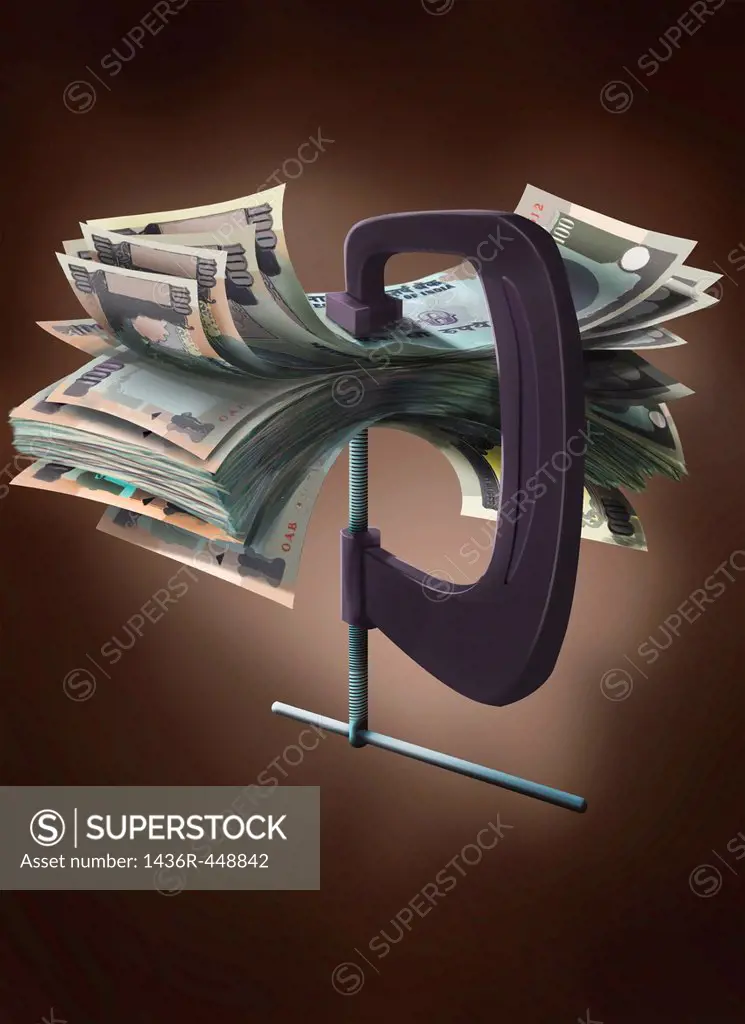 Indian currency notes in a vise grip of a clamp