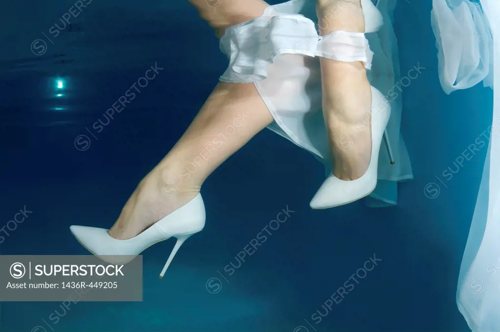 Bride´s feet, underwater wedding in pool