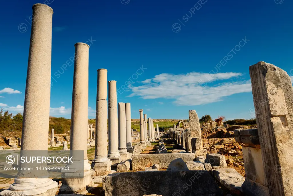 Ruins of stores behind colonade of pillars on main street of Perge archaeological site Turkey