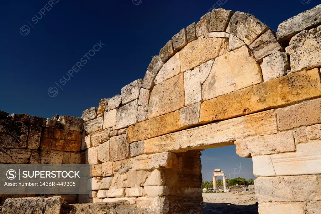 Ancient columns with lintel of Greco Roman temple seen through the stone block south gate at Hierapolis Turkey