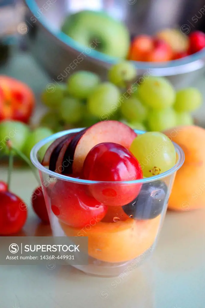Freshly cut fruit salad with apple, grapes, peaches and cherries.