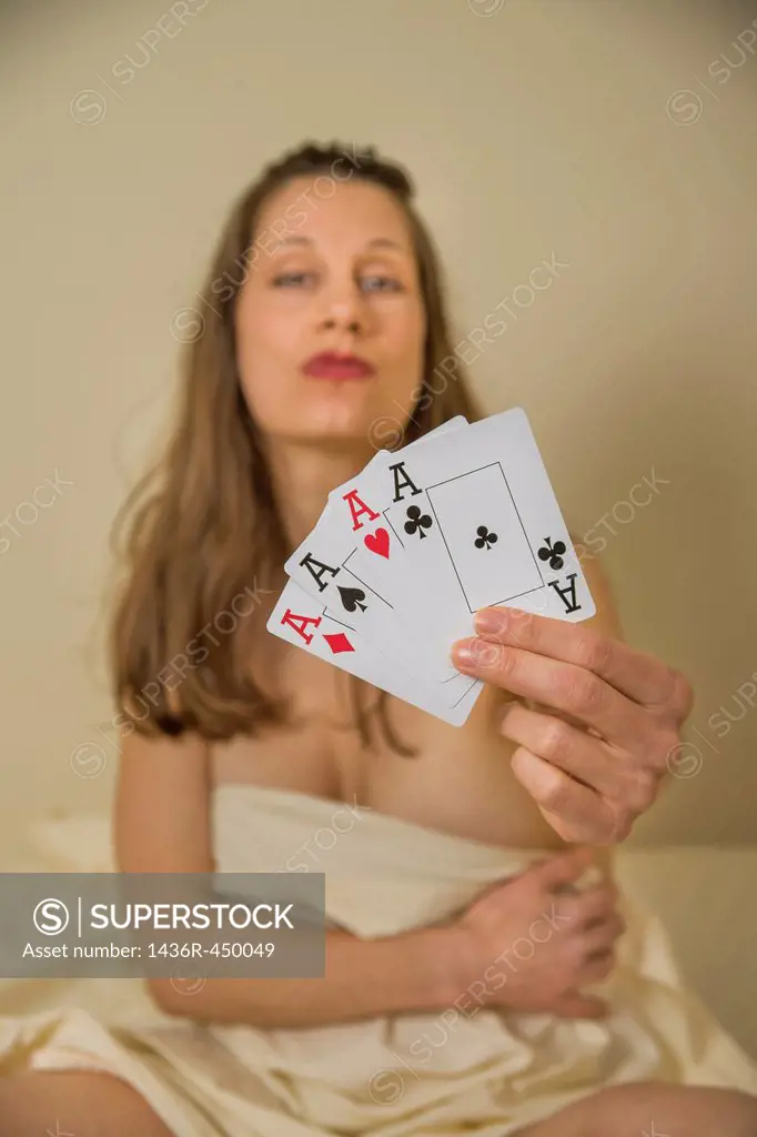 Young woman holding up four aces.