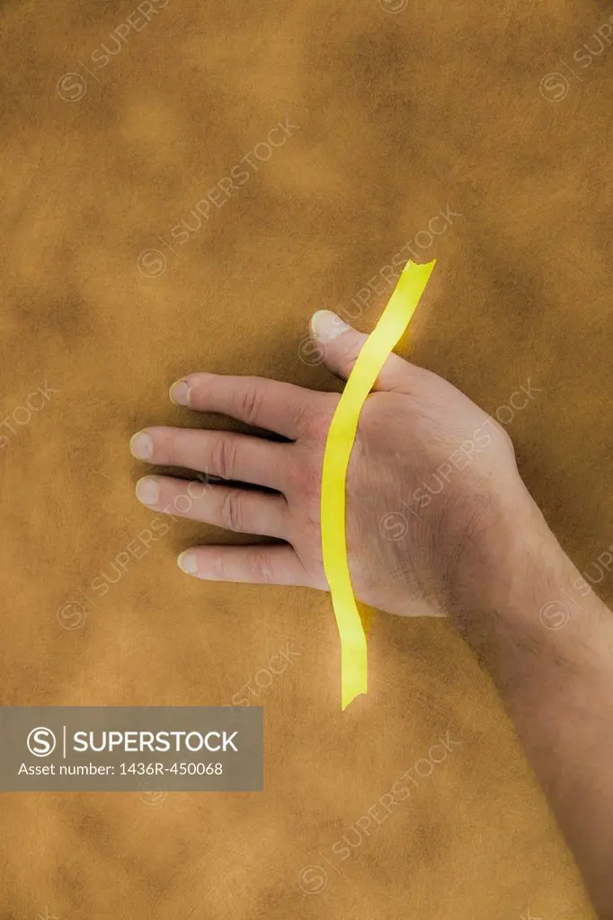 Man's hand taped to a table.
