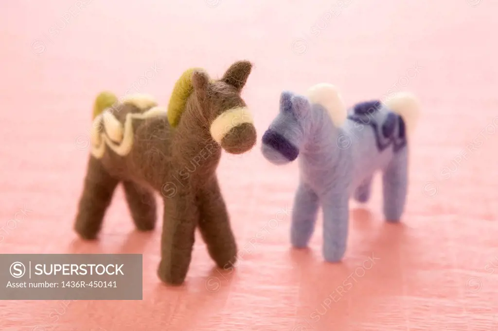 Two Felt Toy Horses on Pink Paper
