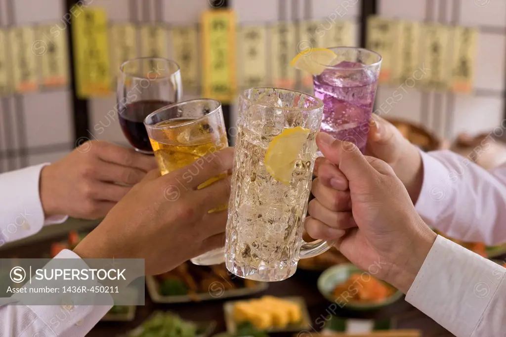 Four People Toasting with Each Other With Various Drinks at Izakaya