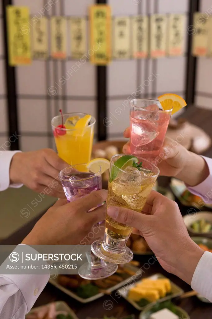 Four People Toasting with Various Cocktails at Izakaya