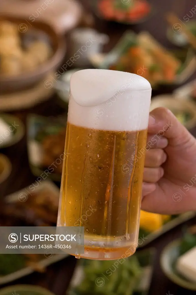 Human Hand Holding Jug of Beer at Izakaya