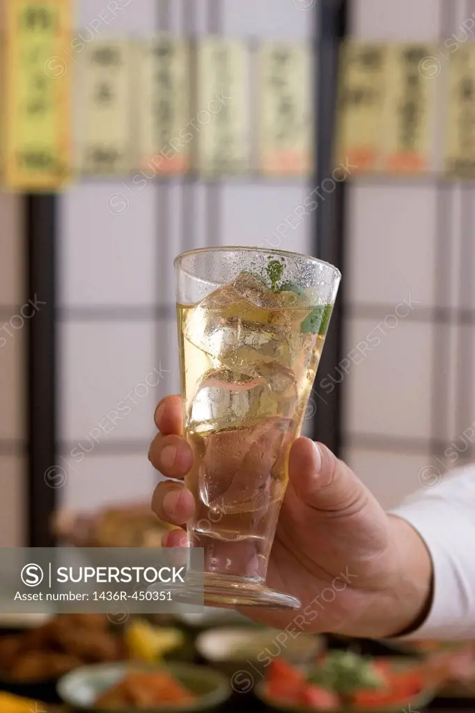 Human Hand Holding Glass of Cocktail at Izakaya