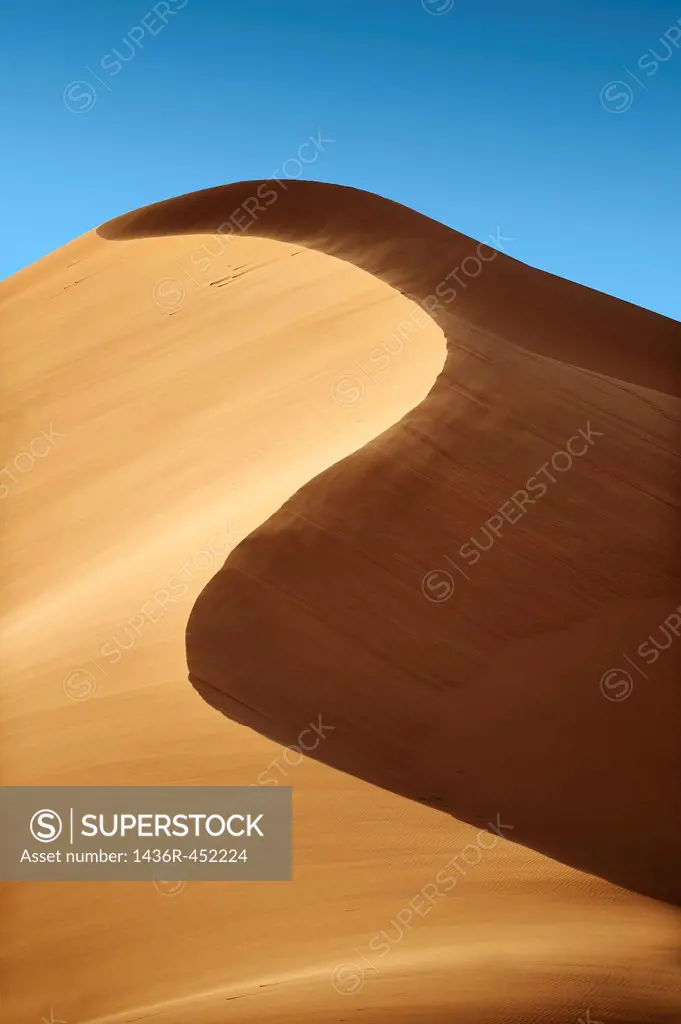 sand being blown on Sahara sand dunes of erg Chebbi, Morocco, Africa.