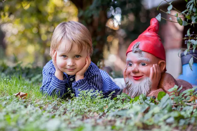 Boy 3 years imitating a garden gnome. Bonn,Germany.