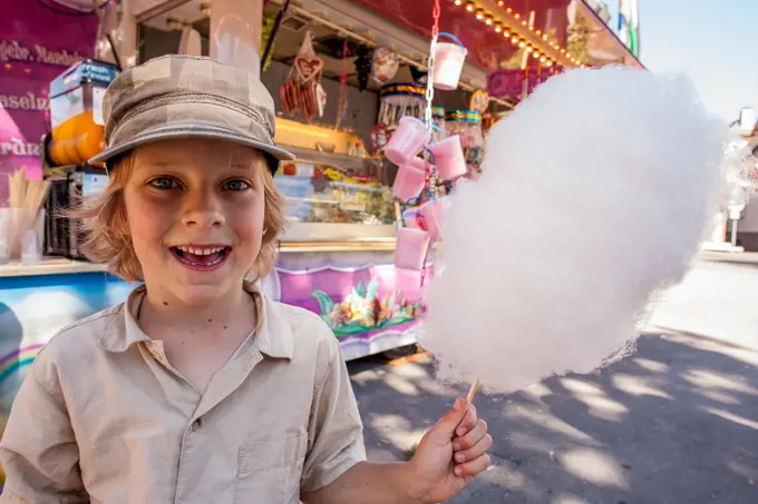 Boy happy to get candyfloss for the first time. Fair, Germany.