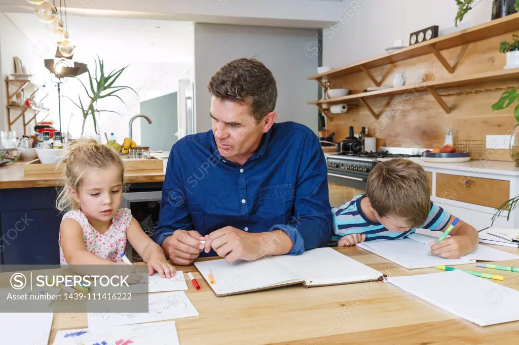 Father helping children with homework at home