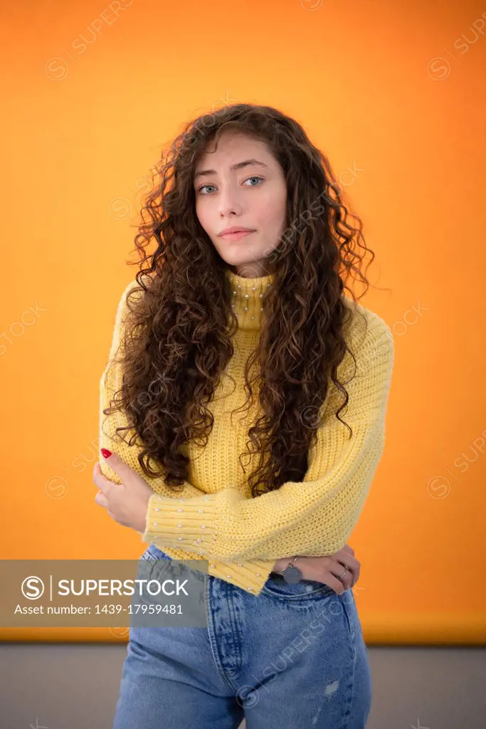 Studio portrait of young woman with long curly hair