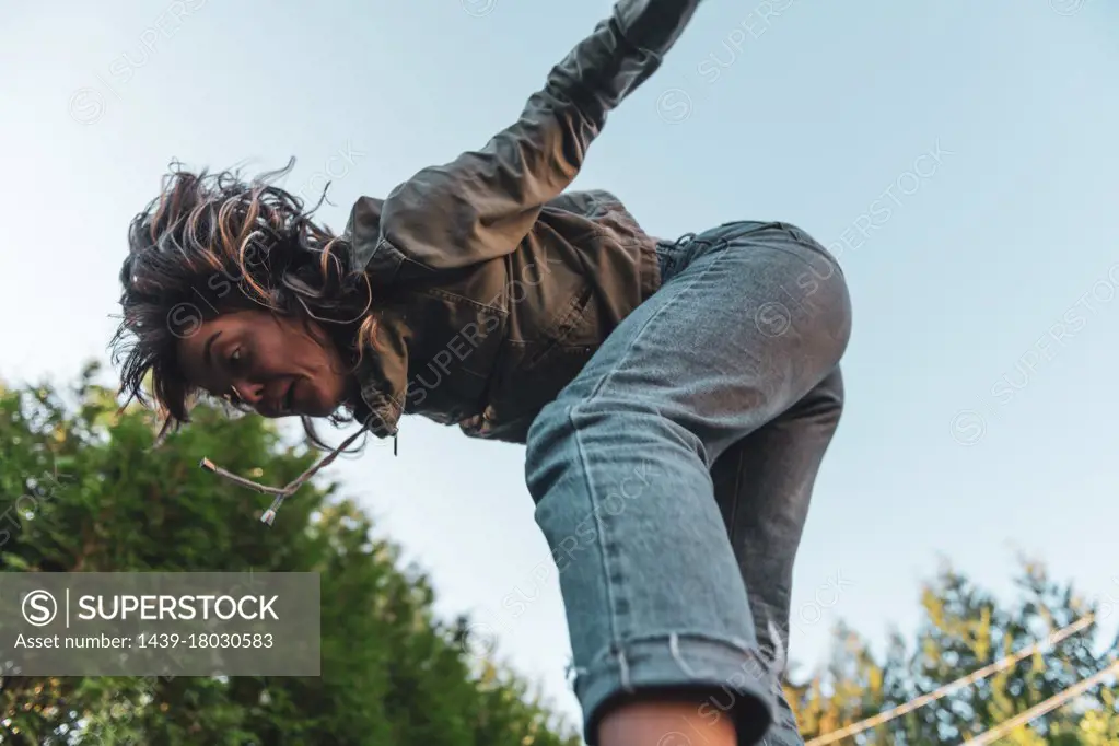 Young woman jumping on trampoline