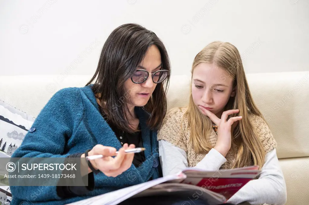 UK, Surrey, Mother assisting daughter doing homework at home