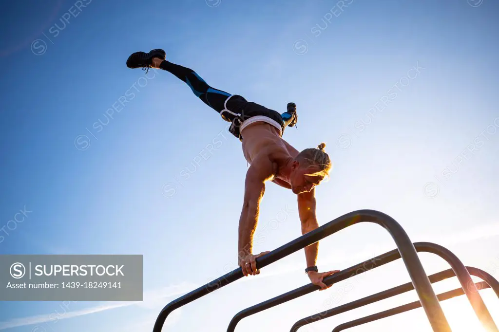 Spain, Mallorca, Man doing handstand at outdoor gym
