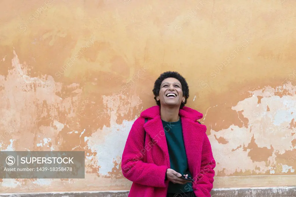 Italy, Tuscany, Pistoia, Woman in pink coat laughing