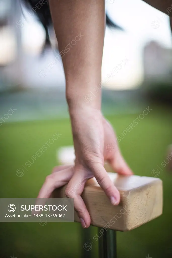 Close-up of hand of female gymnast balancing on blocks outdoors
