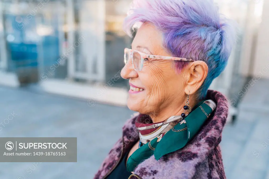 Italy, Smiling fashionable senior woman with purple hair