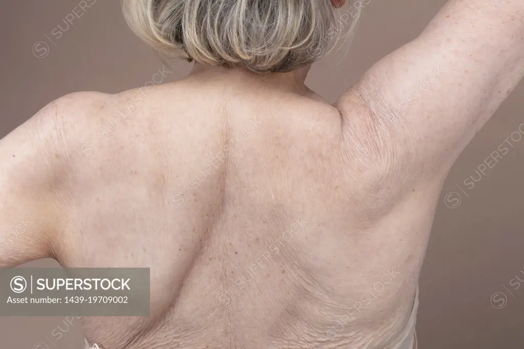 Rear view of shirtless senior woman