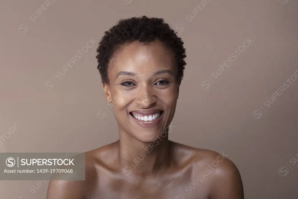 Studio portrait of smiling shirtless woman