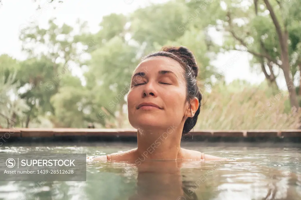 Woman relaxing in swimming pool in spa resort