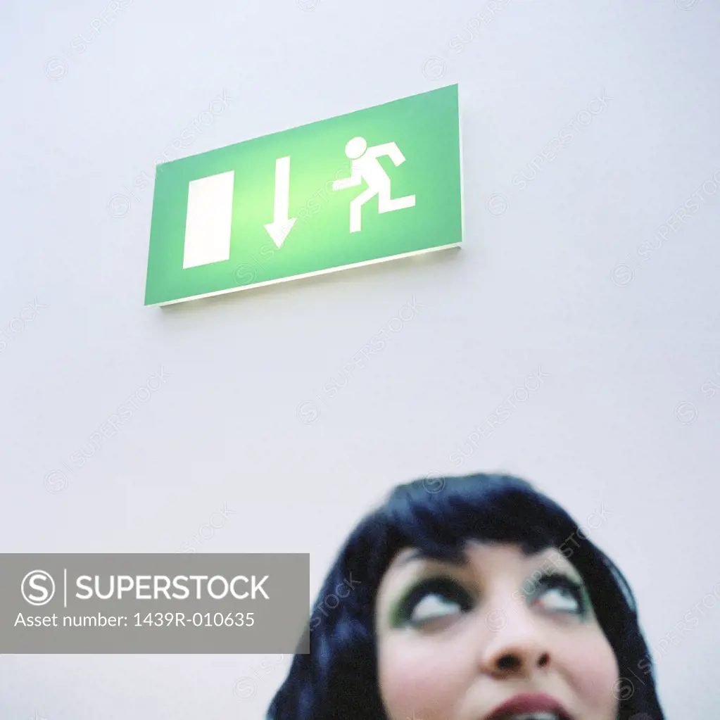 Woman looking toward exit sign