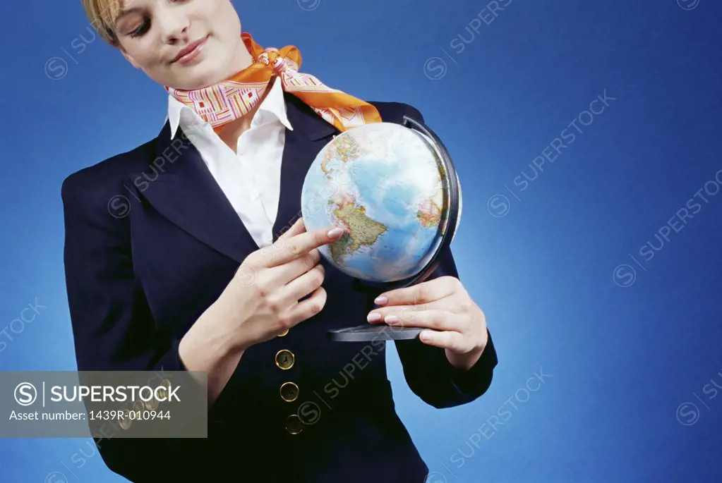 Air hostess pointing to a globe