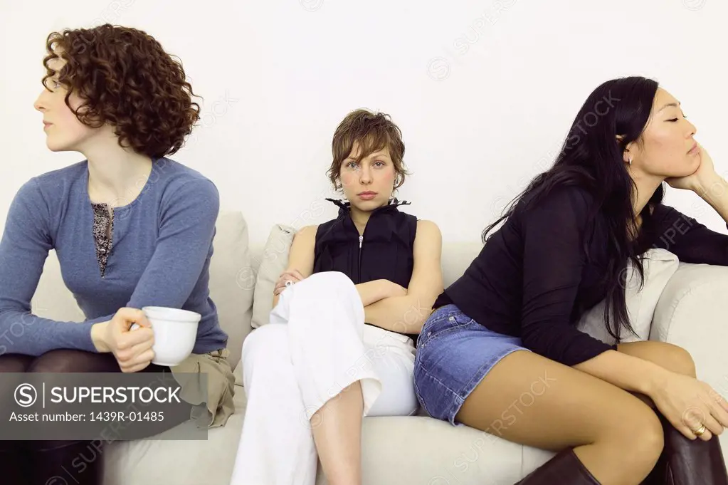 Women sitting back to back on sofa