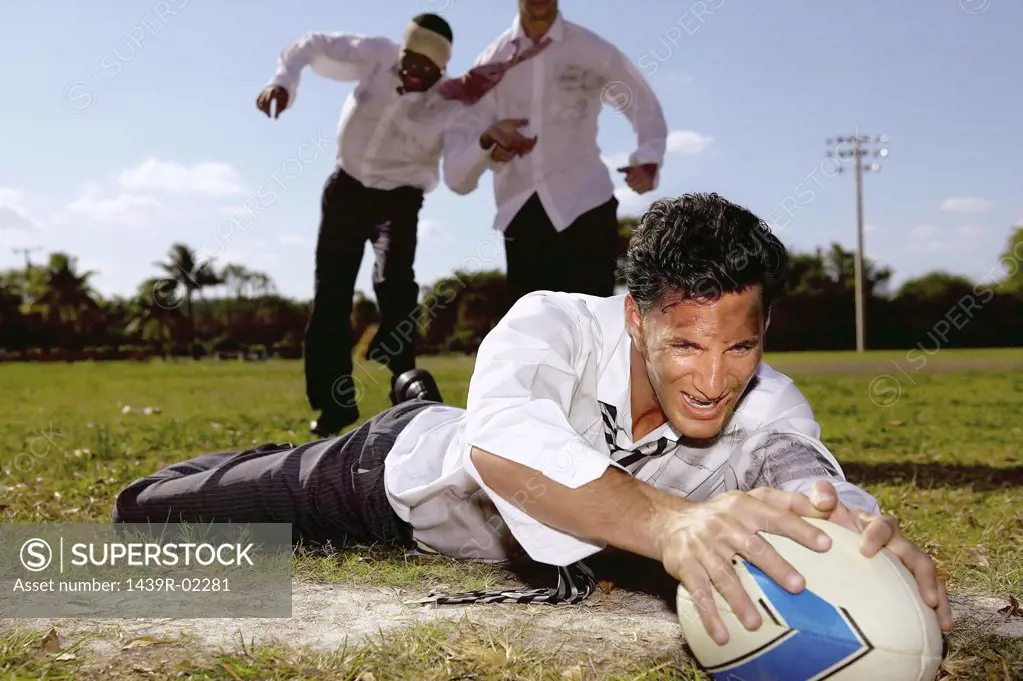 Businessmen playing rugby