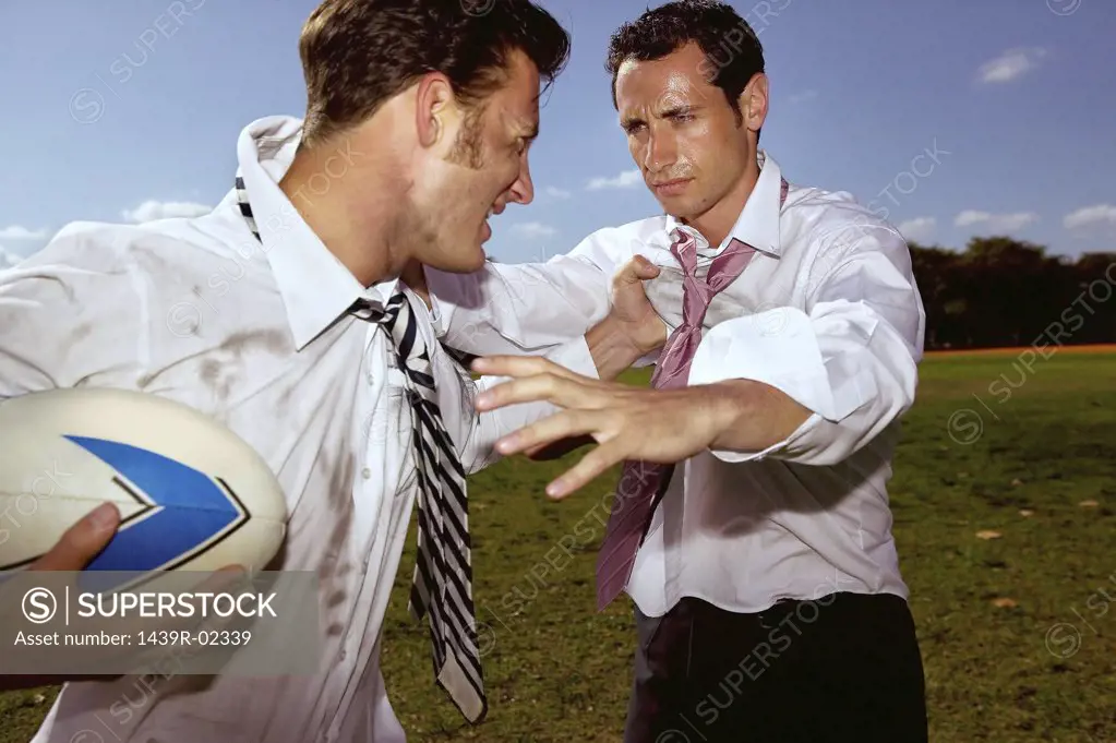 Businessmen playing rugby