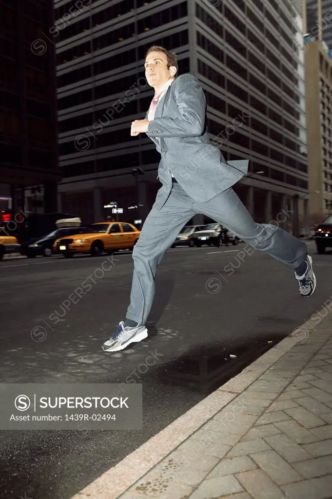 Businessman running through city