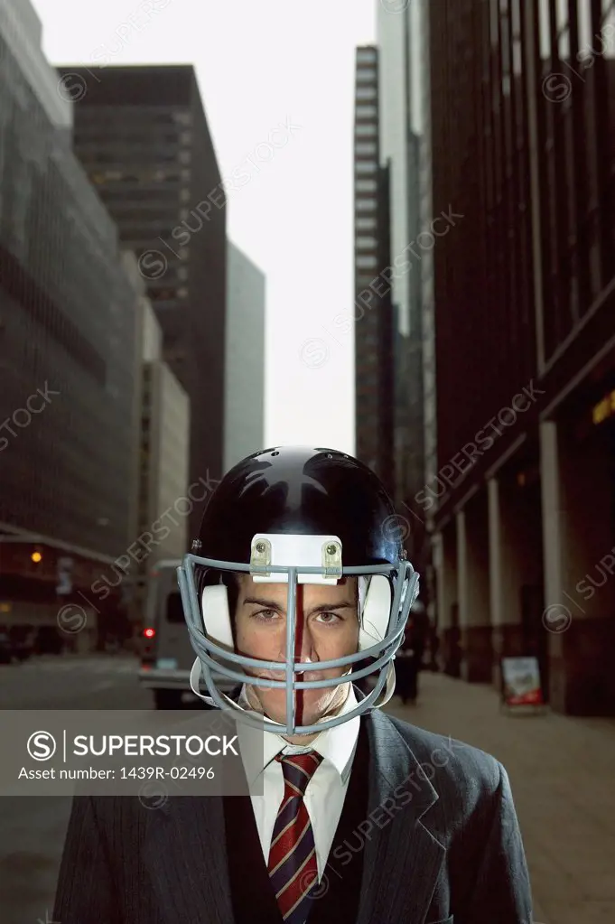 Businessman wearing an american football helmet