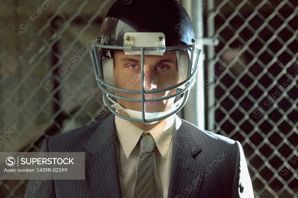 Businessman wearing american football helmet