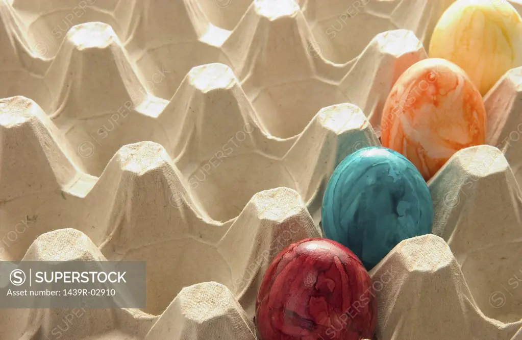 Colourful eggs in carton