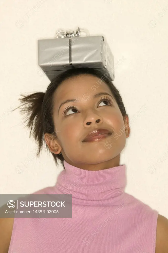 Woman balancing a gift on head
