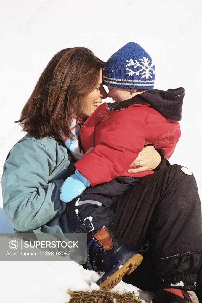 Mother and son hugging in snow
