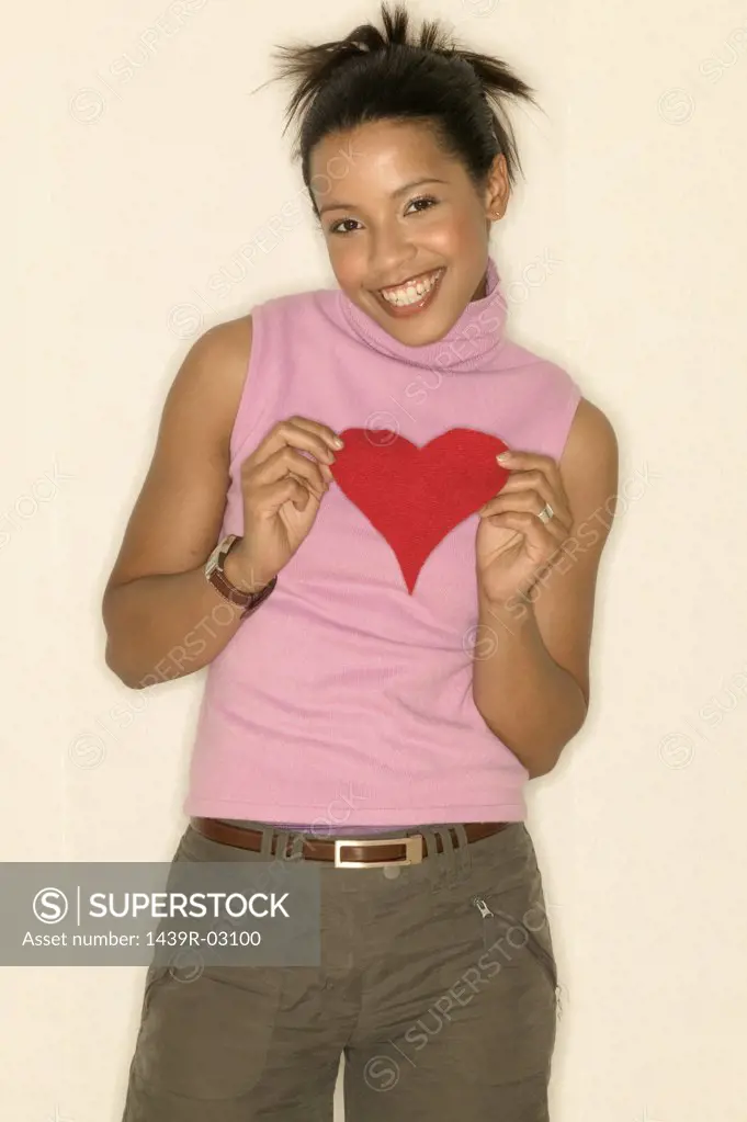 Young woman holding a heart shape