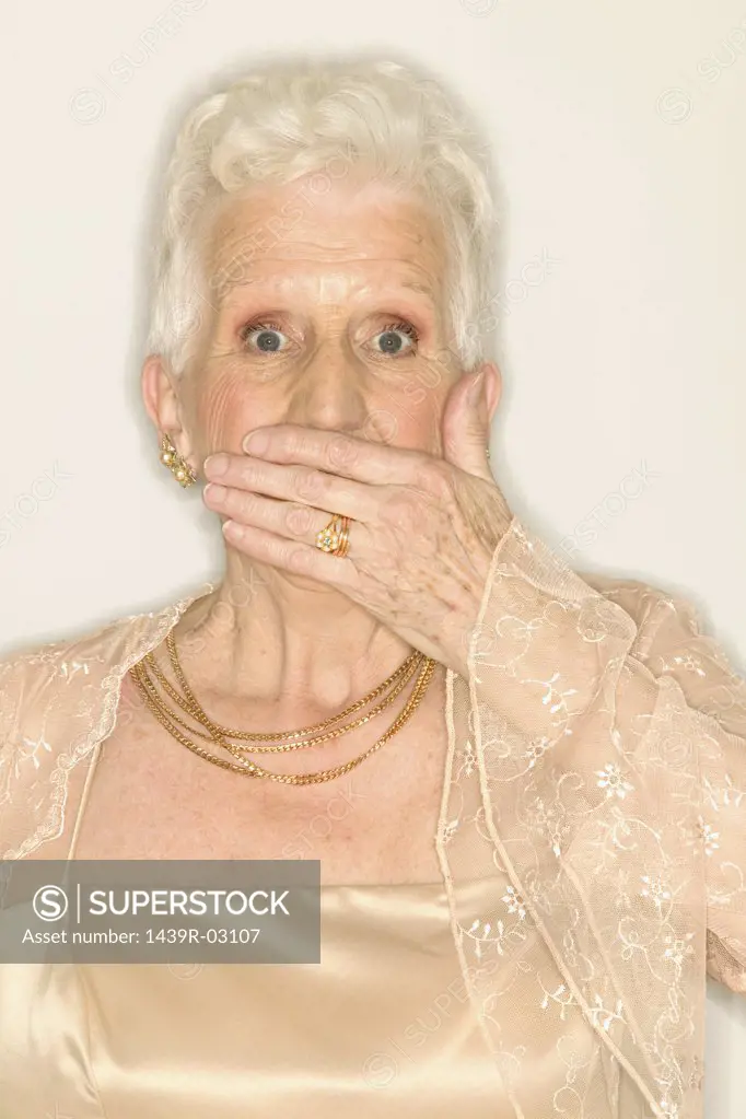 Senior woman covering mouth with hand