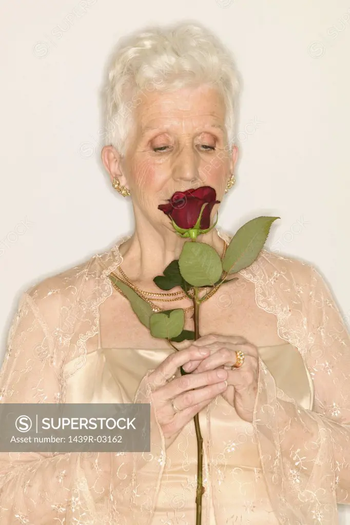 Senior woman sniffing rose