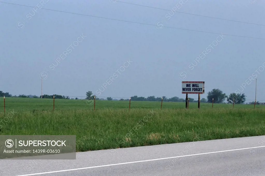 Signpost in field by road