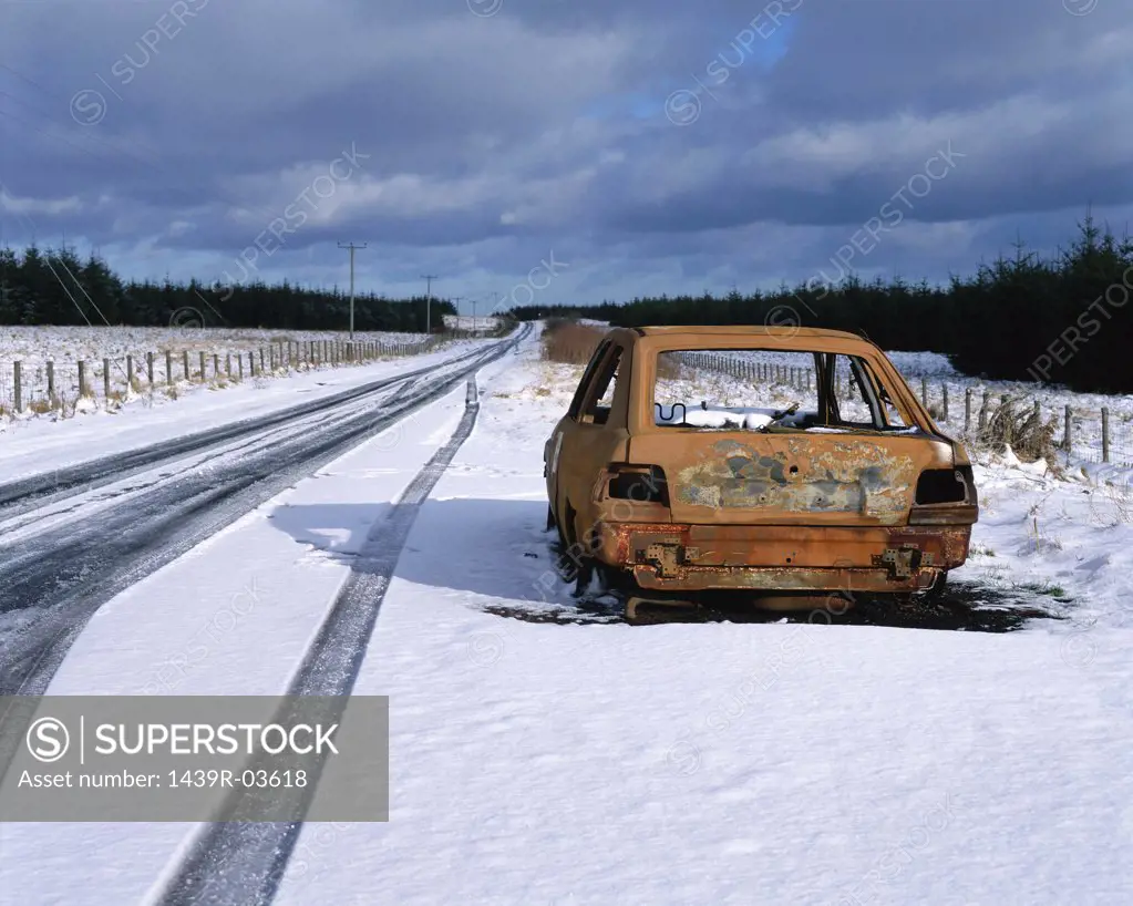 Abandoned car in snow by road