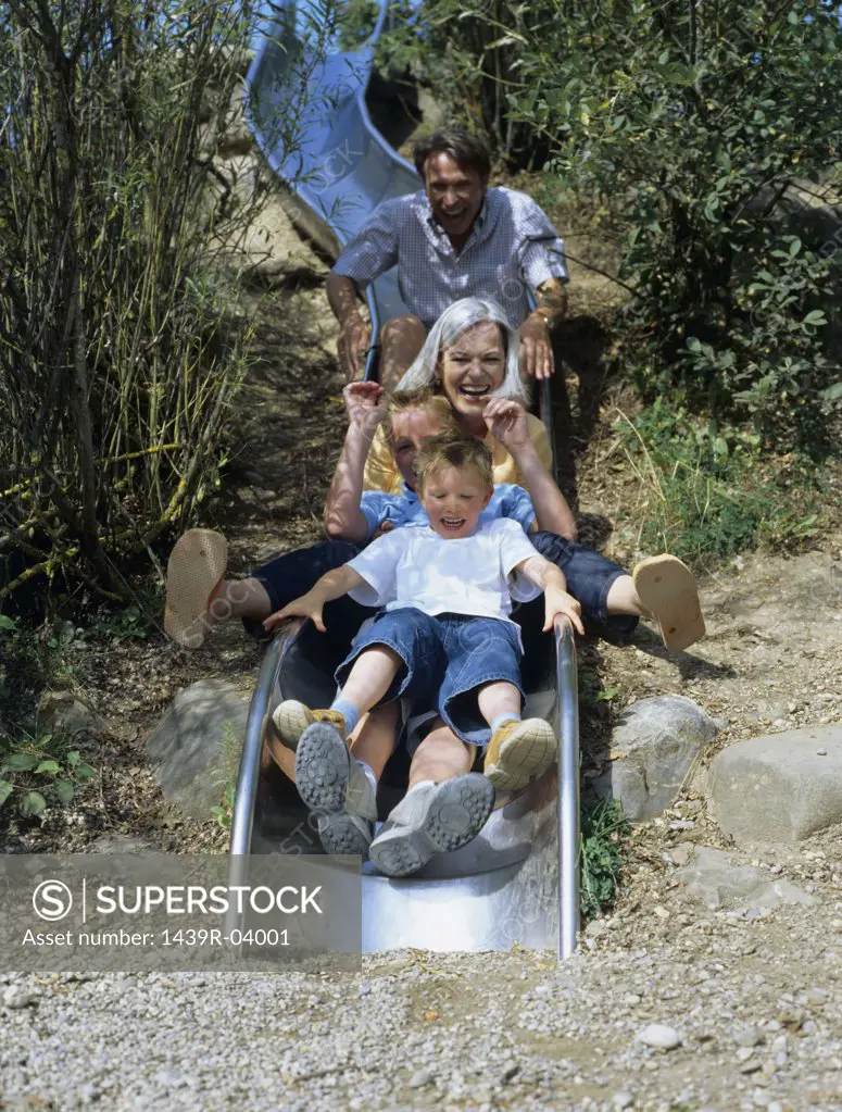 Family enjoy going on a slide.