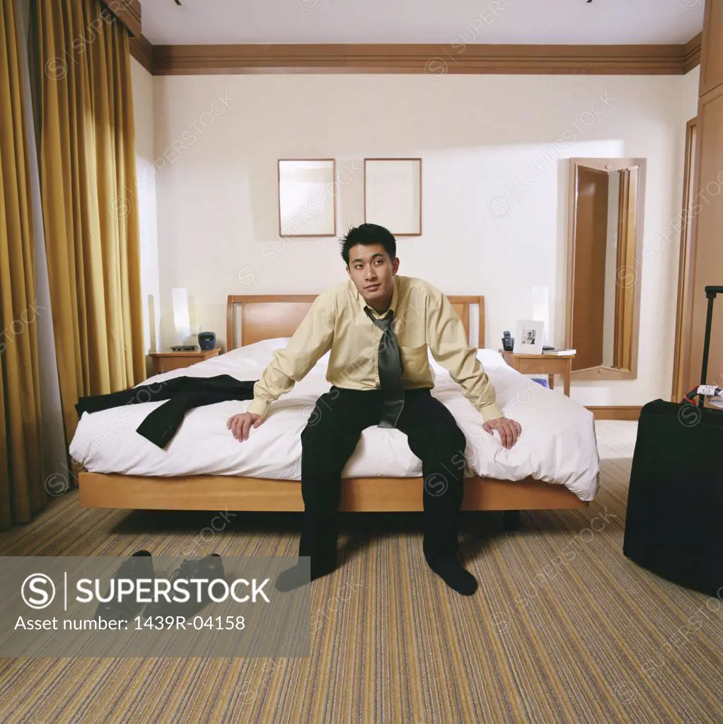 Businessman sitting on edge of bed